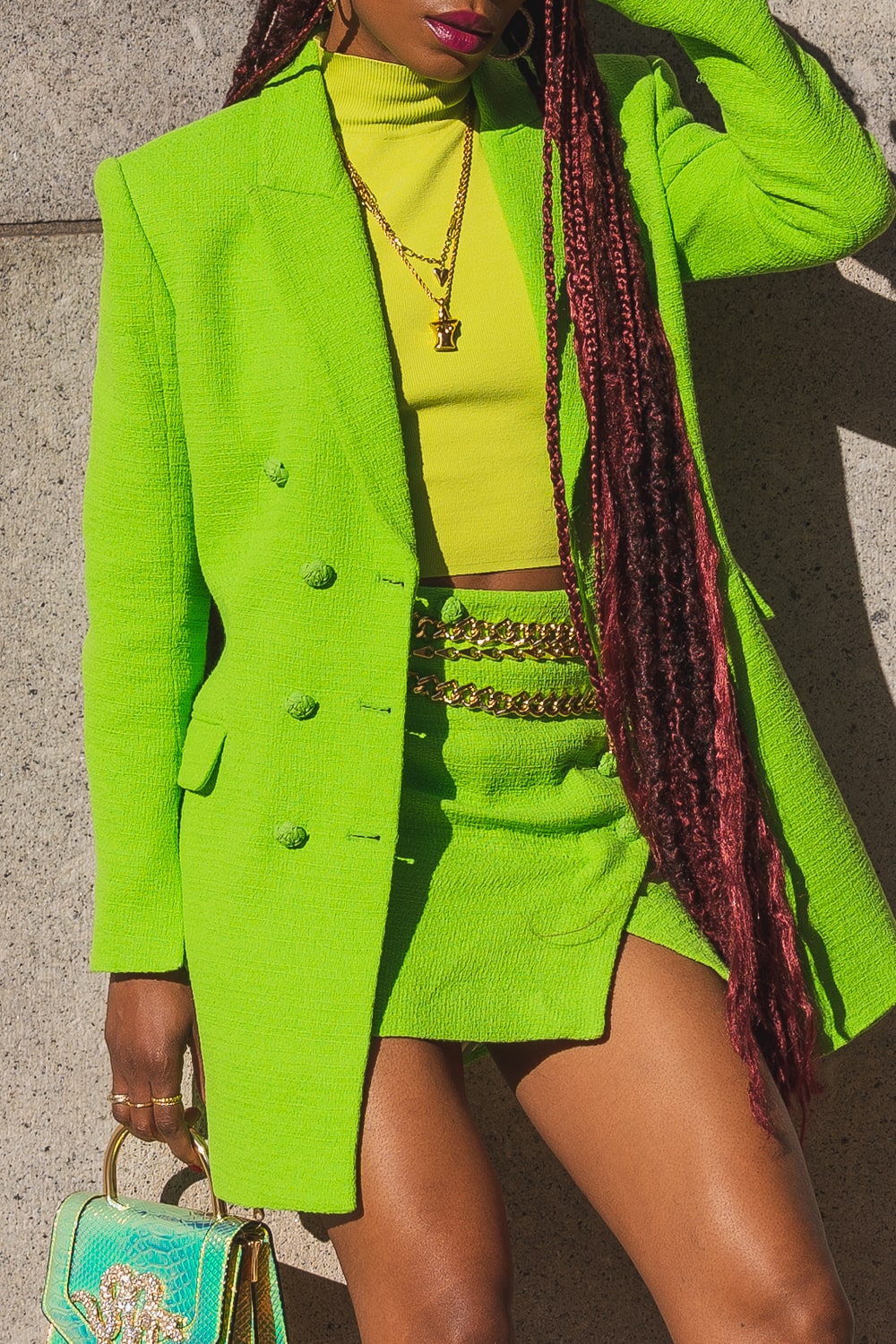 Lapo Lounge - Callisto Gold Chain Belt styled on a black woman with a green blazer, green mini skirt & green turtle neck