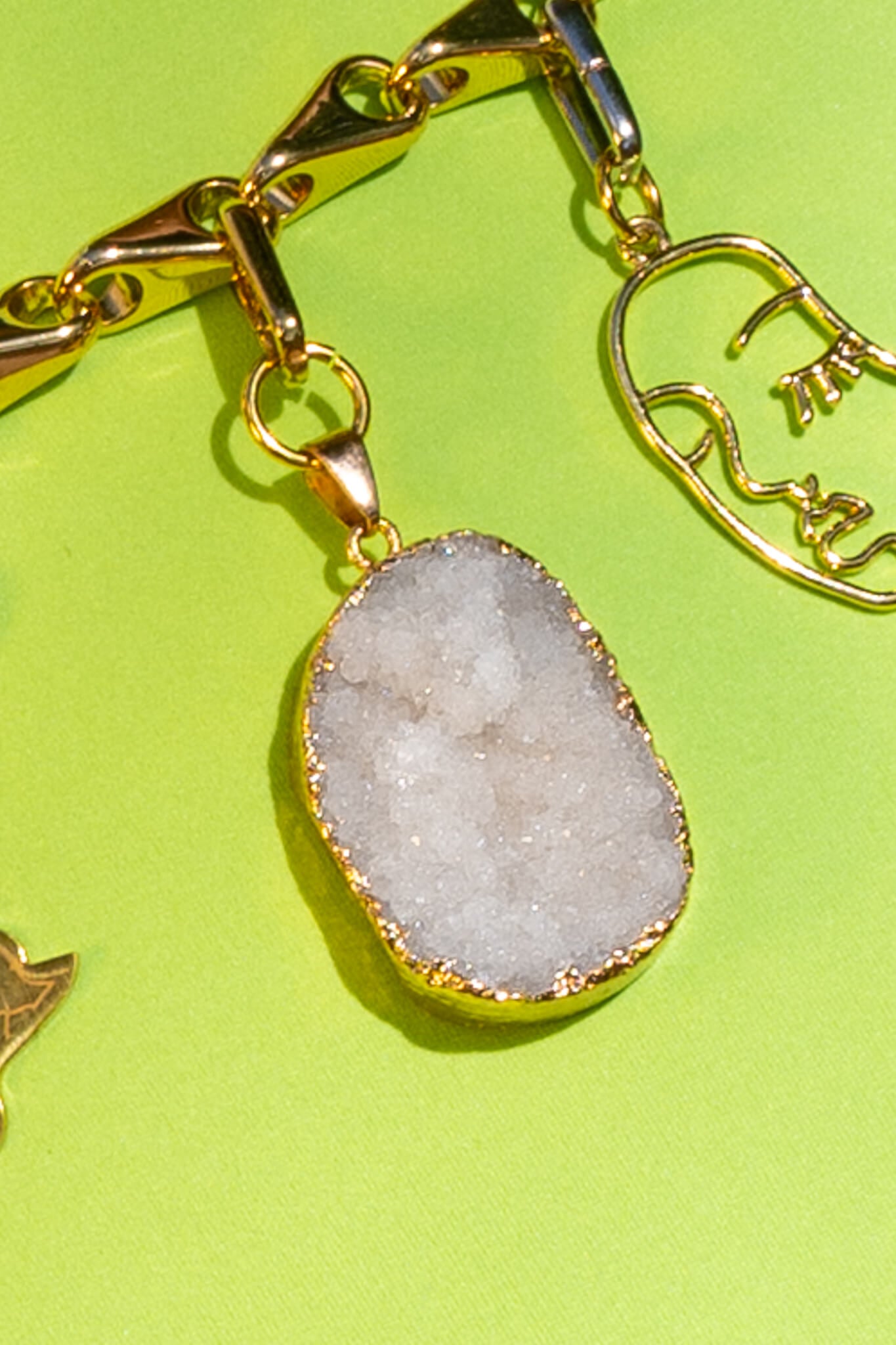 White stone charm clipped on a chain belt